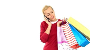Woman talking on the phone and holding shopping bags