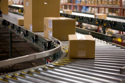 Photo of shipping boxes on a conveyor belt.